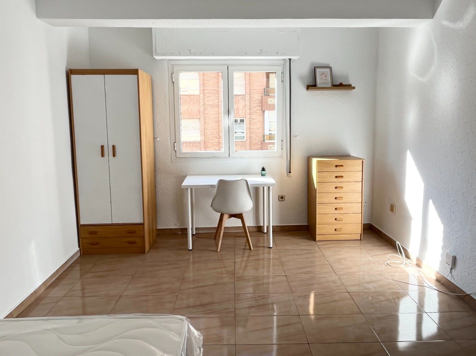 Habitación acondicionada con armario, escritorio y cómoda
