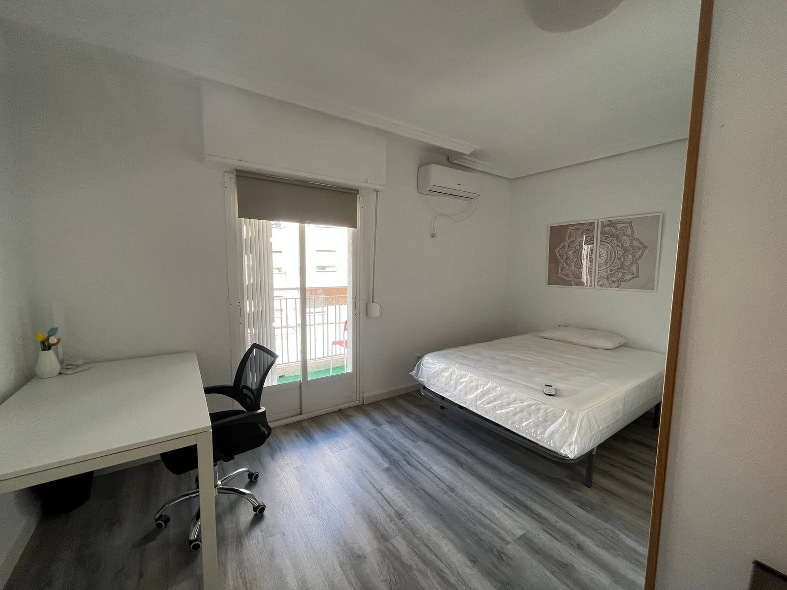 Habitación acondicionada, con cama, escritorio y balcón, en uno de los pisos que gestionamos
